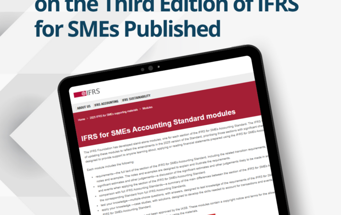Professional corporate desk featuring a laptop displaying financial reports alongside open accounting text documents and a branded IFRS educational training binder.